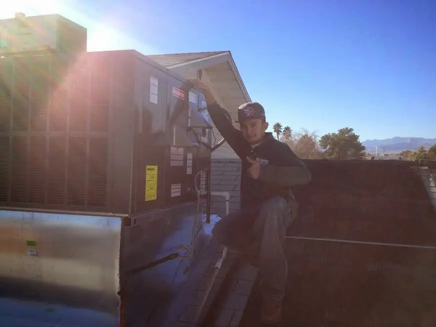 HVAC technician performing AC Tune-Up on a rooftop unit in Fort Atkinson